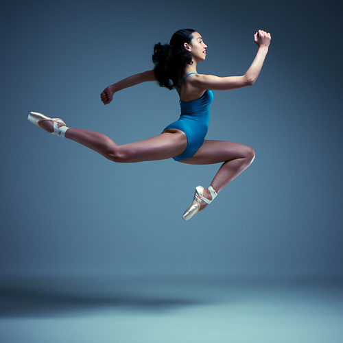 Leaping dance in blue leotard